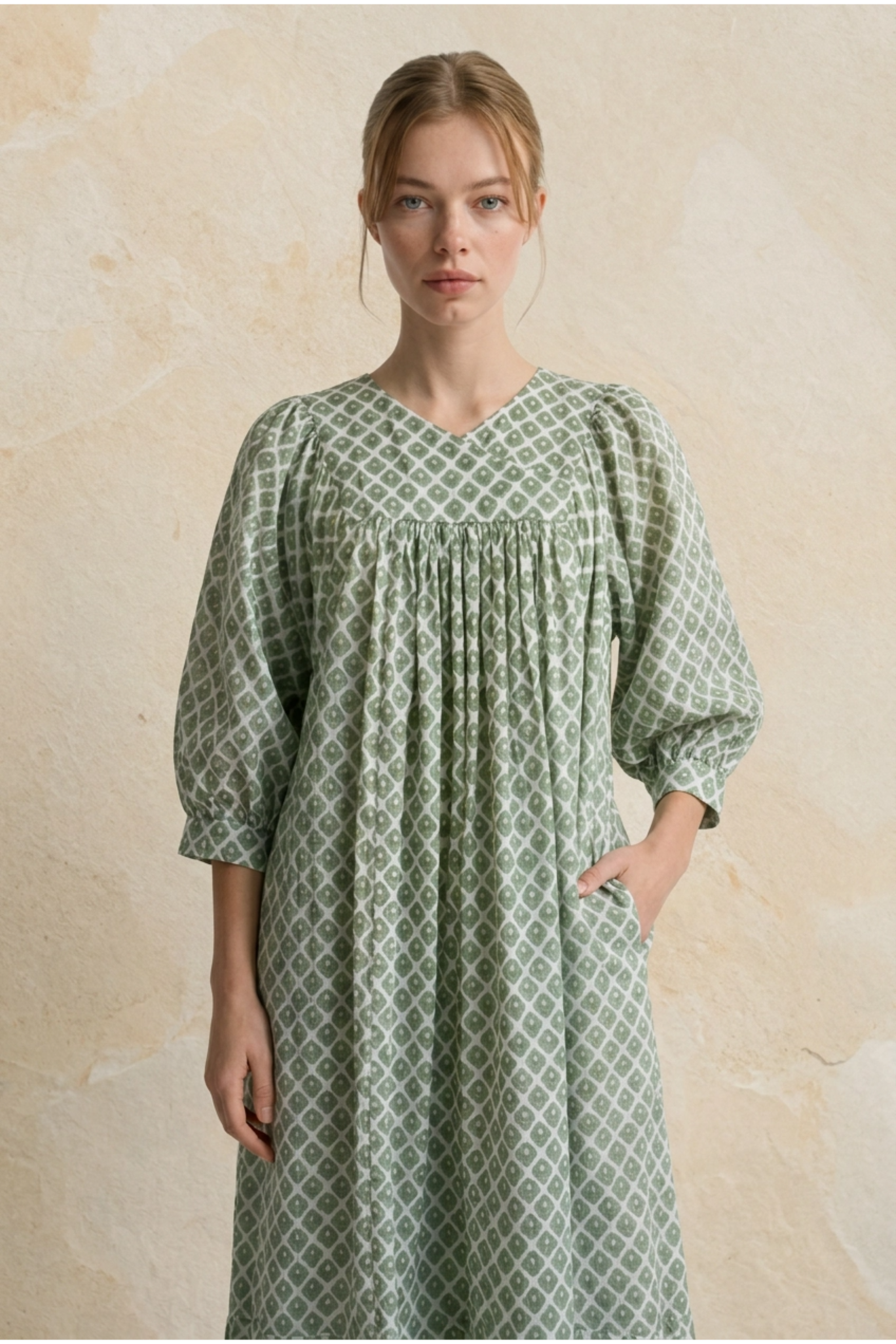Woman wearing a green patterned dress against a beige background